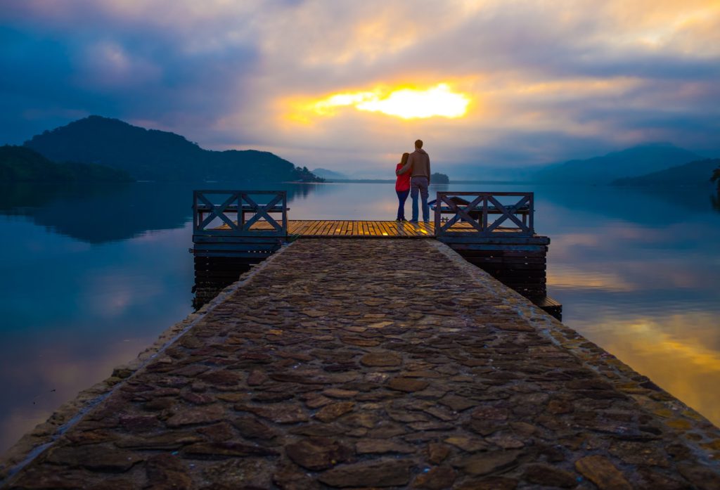 Couple on dock looking at sunset