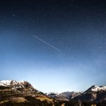 shooting star over snow covered mountains